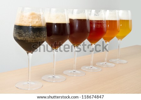 Six glasses with different beers on wooden table