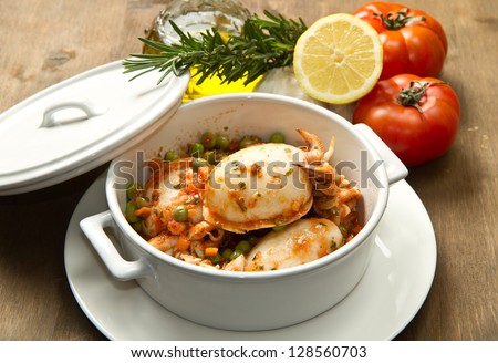 a white bowl with cuttlefish with peas and fresh tomatoes, lemon and oil