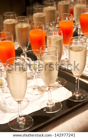 Row of glasses filled with champagne lined up ready to be served