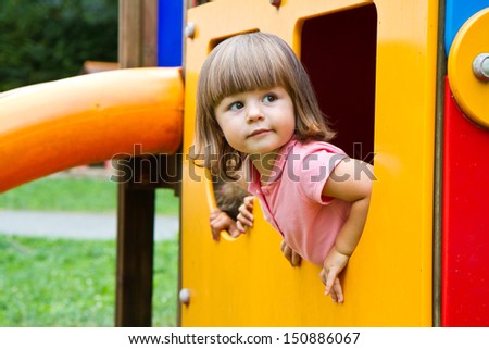Happy smiling child   in small house on playground