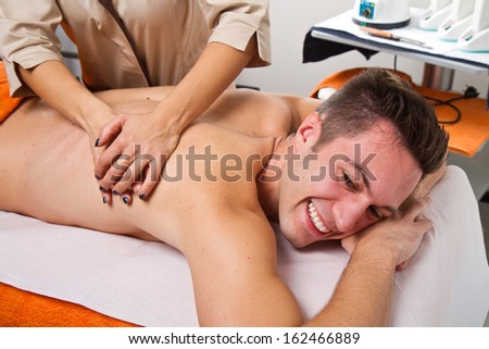 attractive man having a back massage in a beauty center