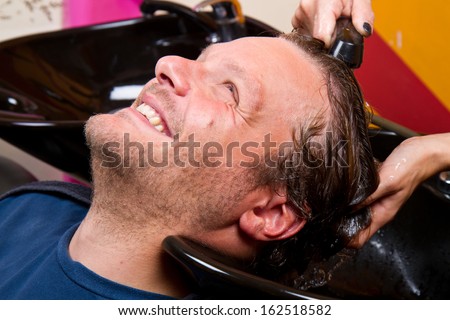 Washing man hair in beauty parlour hairdressing salon