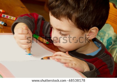 child draws with color pencils