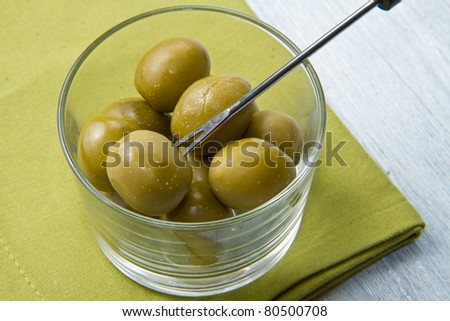 A small bowl of olives on a table  on wooden table