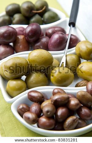 A small bowl of olives on a table  on wooden table