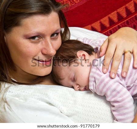 Mother embracing baby asleep