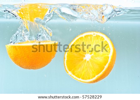 Oranges splashing into water