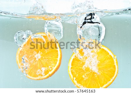 Oranges splashing into water