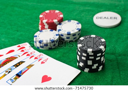 Poker chips and cards isolated against green felt