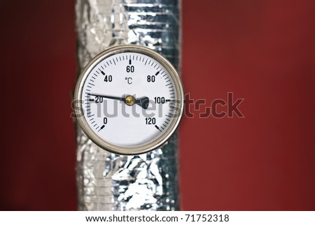 Celsius thermometer temperature gauge from a heater isolated against a red background