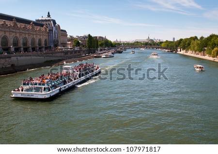 PARIS, FRANCE - MAY 28: Seine river with tourists ship in Paris, France on May 28, 2011. The Seine is a 776 km long river and an important commercial and tourist waterway within the Paris area
