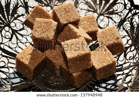 pieces of brown sugar in vintage metal bowl