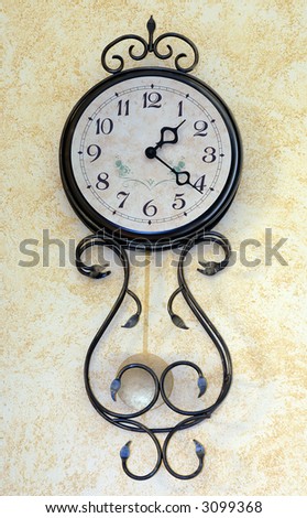 wall clock with a pendulum; wrought decoration;