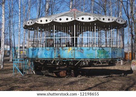 old blasted carousel in park with graffiti