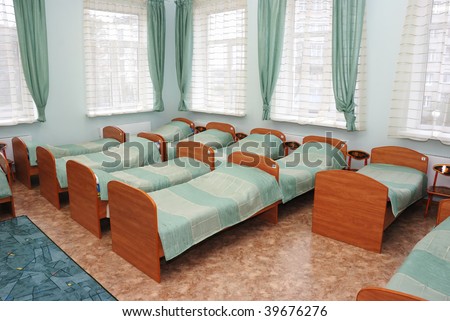 rows of little  beds in kindergarten bedroom