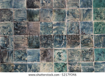 a wall finished with glazed tile of blue, green and grey colours