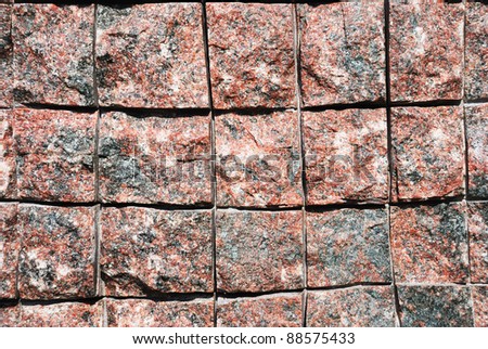 surface of a reddish and grey granite block
