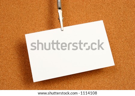 Empty card over a cork board with a small clip