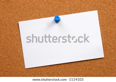 Empty card on a cork board with a small thumb tack