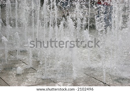 Multiple jets of water in a fountain, close view with lots of movement.