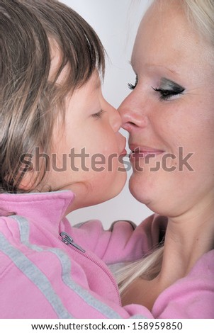 A mother as she receives a kiss from her young daughter