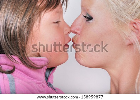 A mother as she receives a kiss from her young daughter