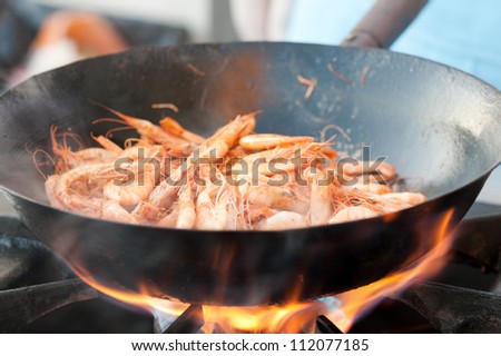 A group of fresh shrimp in the frying pan on fire