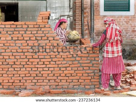 KATHMANDU, NEPAL - DECEMBER 17, 2012: Nepali construction women workers making brickwork.Economic contribution women was substantial but unnoticed because their traditional role was taken for granted