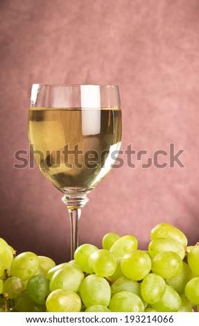White wine in wine glass and fresh green grapes