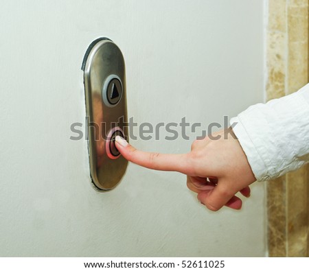 Woman pressing elevator button to go down