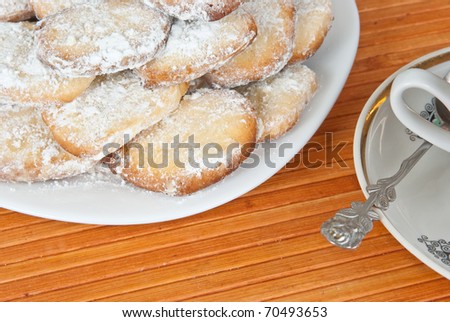 Cookies on plate and tea cup on bamboo mat