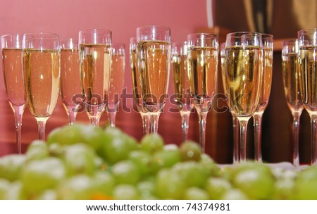 Sparkling wine in glasses as welcome drink with green grapes on foreground