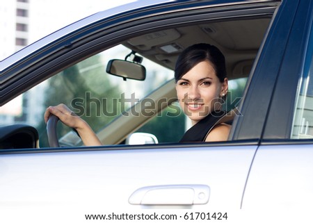 Beautiful happy businesswoman driving her car