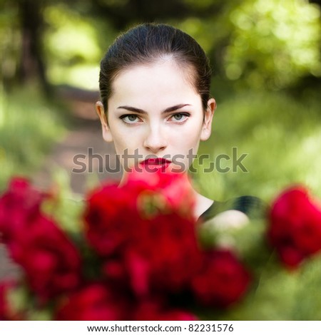 Beautiful woman with red lips giving flowers. Close up portrait