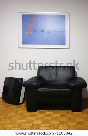 nice arm-chair in the living room with TV and picture