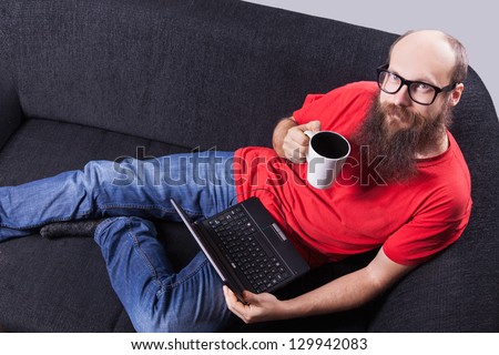A man on the sofa, watching a movie and drinking - (Series)