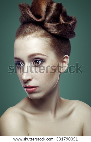 Beauty portrait of young woman with brown hair, dark brown eyes and a lot of freckles and hairstyle and white skin on green background looking at camera, studio shot.