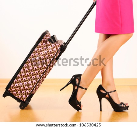 Woman's legs and travel suitcase