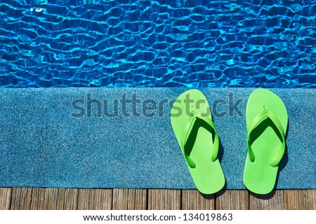 Green slippers by a swimming pool