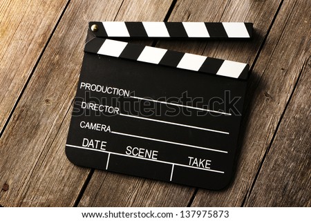 Movie production clapper board over wooden background
