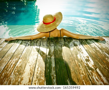 Woman in hat relaxing at the pool Woman in hat relaxing at the pool