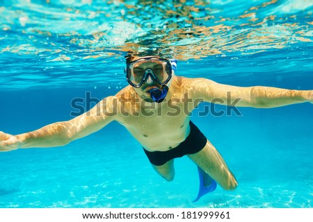 Man with mask snorkeling in clear water