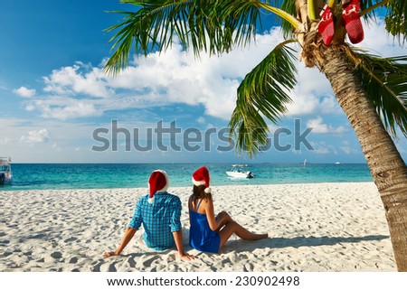 Couple in blue clothes on a tropical beach at Christmas.