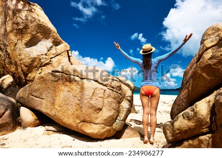 Woman at beautiful beach wearing rash guard. Seychelles, Curieuse island