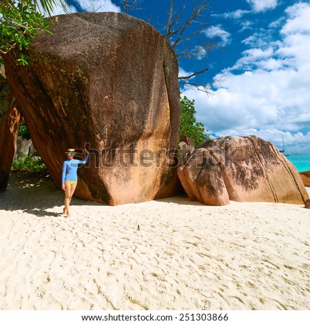 Woman at beautiful beach wearing rash guard. Seychelles, Praslin, Anse Lazio