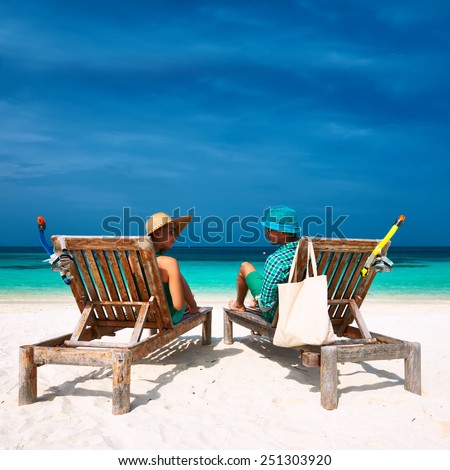 Couple in green relax on a tropical beach at Maldives