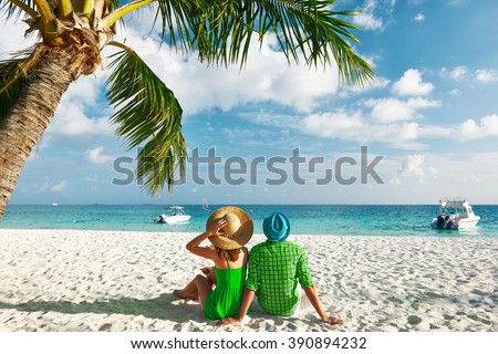 Couple in green clothes on a tropical beach at Maldives