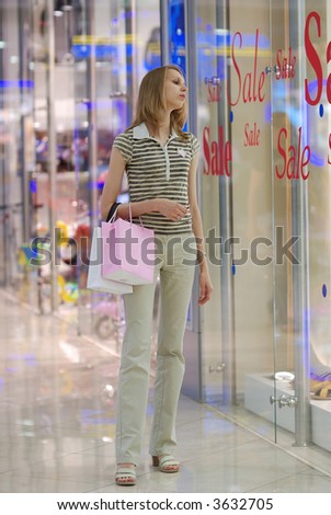 Girl in shopping mall looking on a show-window with \