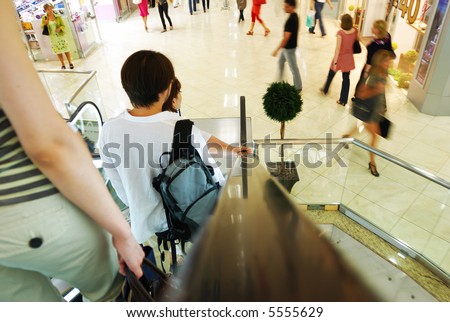 People in escalators at the mall. No brand names or recognizable faces.