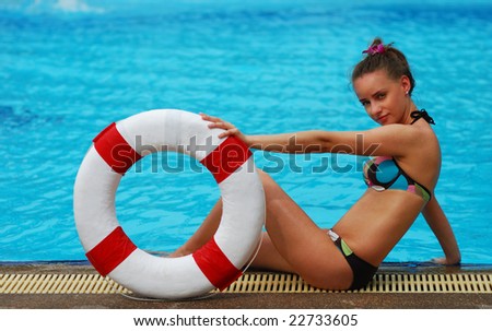 Girl near tropical pool with life saving buoy